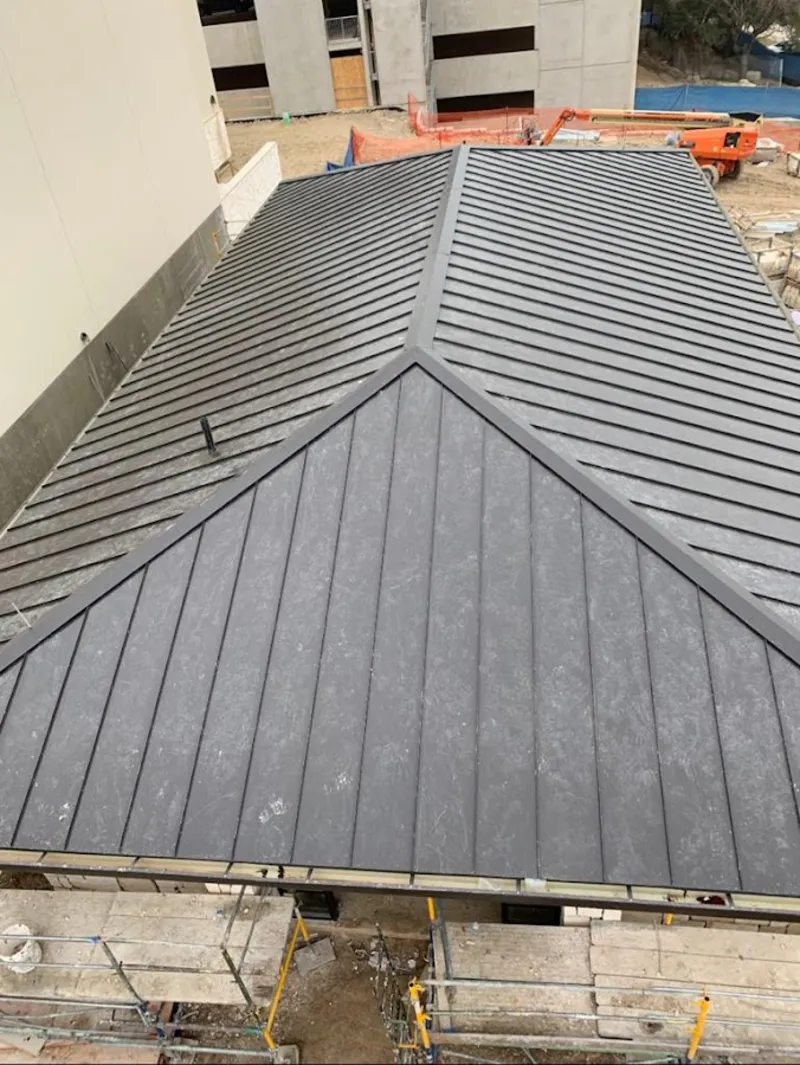 Commercial metal roof construction with crane equipment in West Boylston